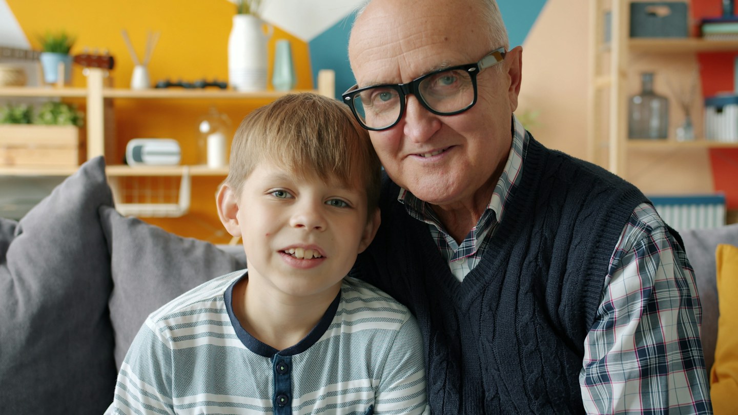 A grandfather and grandson sitting together at home